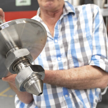 A close-up of a high-performance spray dryer atomizer, a critical component of our industrial spray drying equipment, held by an engineer.