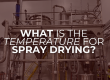 Industrial spray drying system with stainless steel vessels and pipes inside a production facility, featuring the text “What is the temperature for spray drying?”