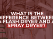Text graphic placed over a flash drying system setup in an industrial facility. The bold question in white and red reads: ‘What is the difference between a flash dryer and a spray dryer?’ with metal staircases, pipes, and tanks in the background.